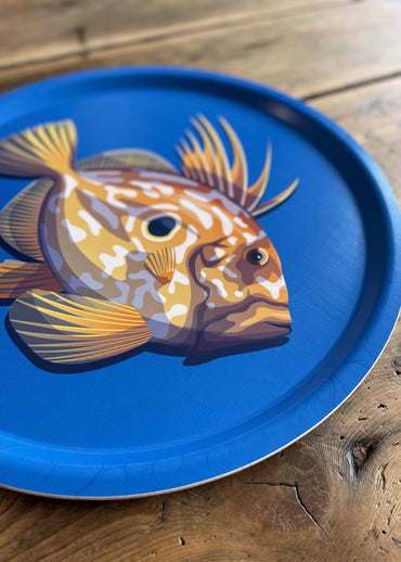 Plateau rond bleu avec un saint-pierre dessus