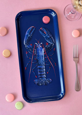 Petit plateau en bois d'un poisson rouge sur fond bleu