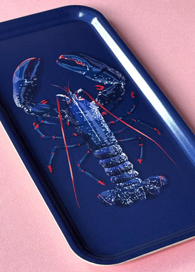 Petit plateau en bois d'un poisson rouge sur fond bleu