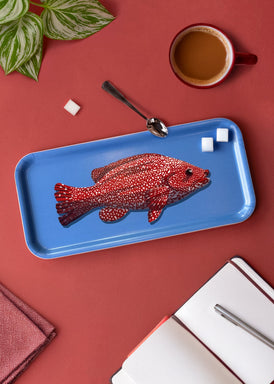 Petit plateau en bois d'un poisson rouge sur fond bleu