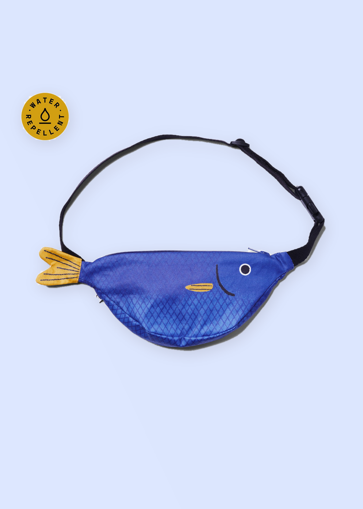 Sac banane enfant Saithe bleu Don Fisher fermé, sangle noire et badge déperlant, fond bleu lavande pastel