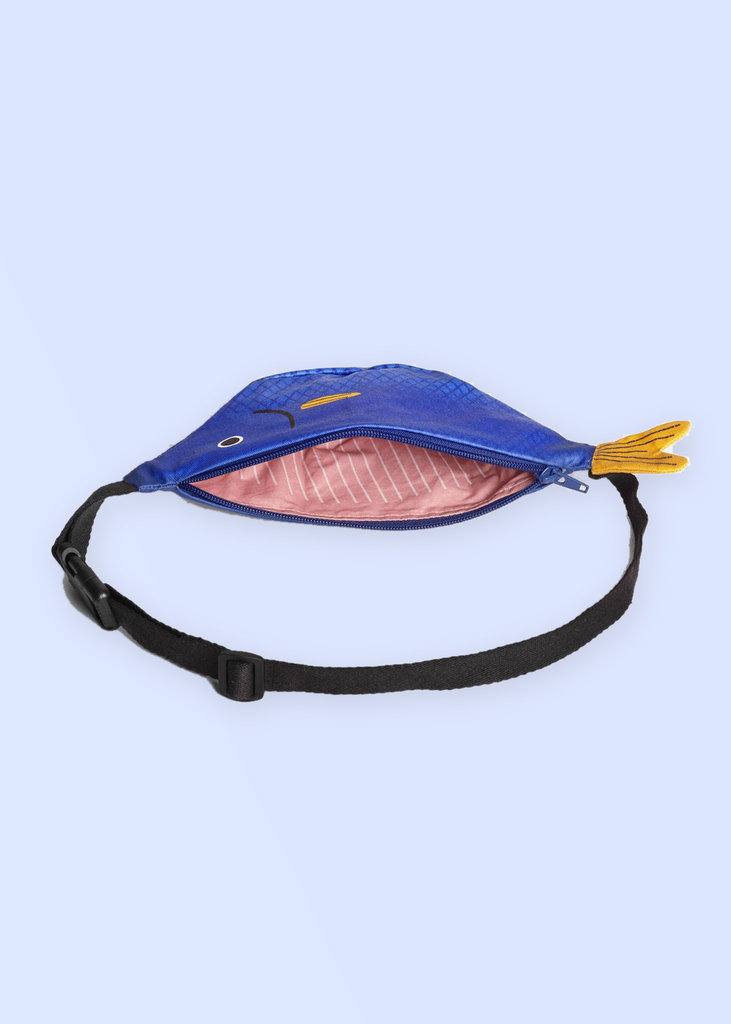 Sac banane enfant Saithe bleu Don Fisher ouvert, doublure rose et sangle noire, fond bleu lavande pastel